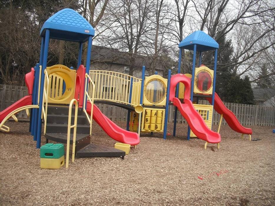 Colorful playground structure with slides and steps on wood chips