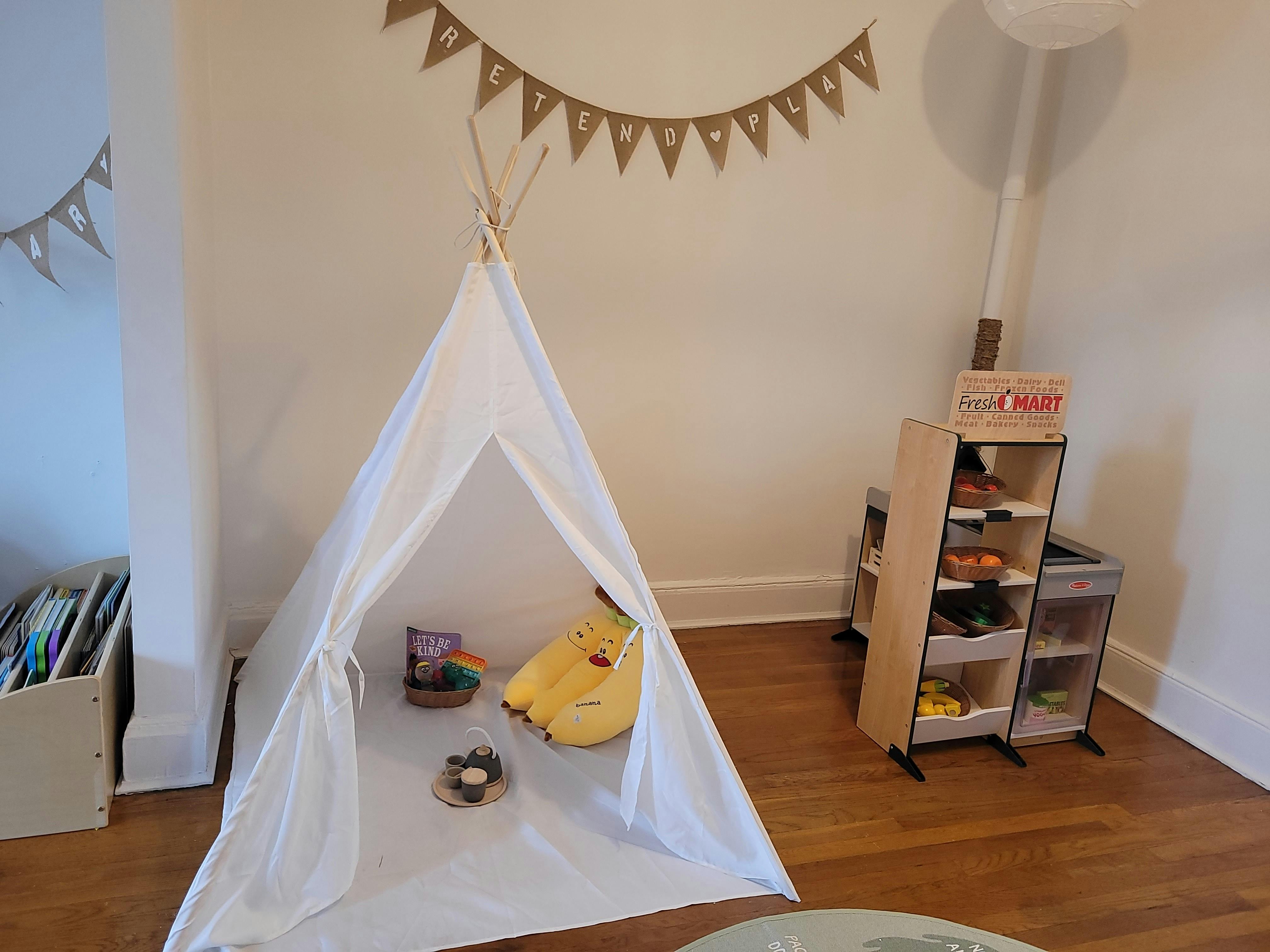 White teepee with a banana plushie and a small nest inside