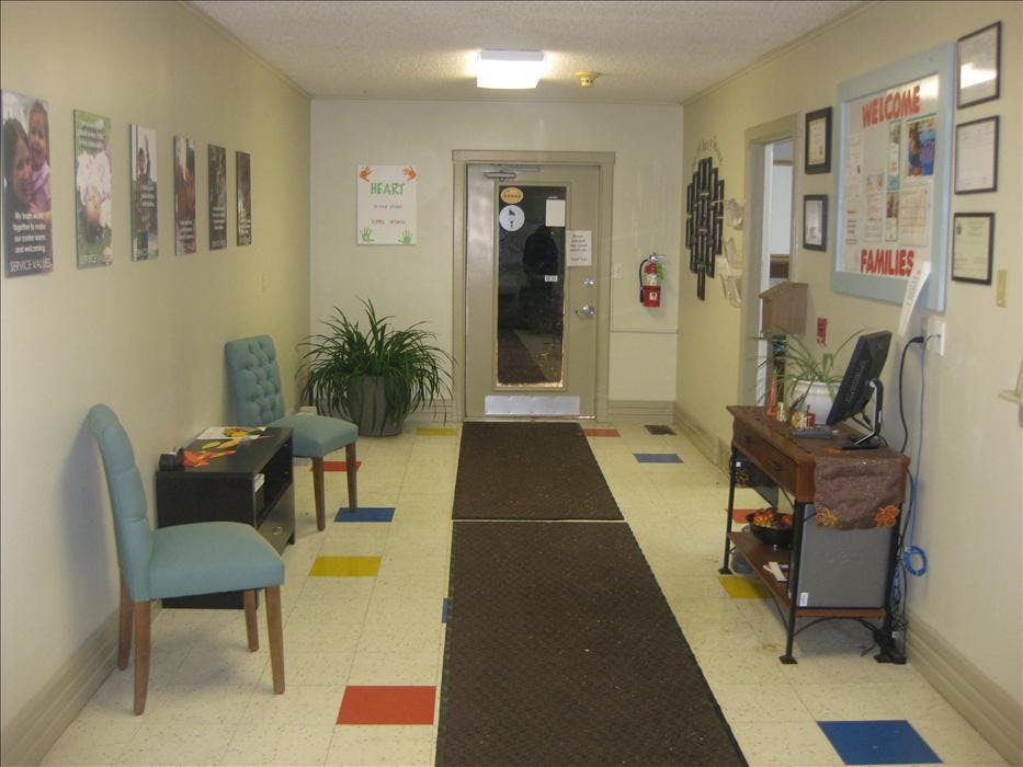 Waiting room with two chairs, a plant, and a welcome sign