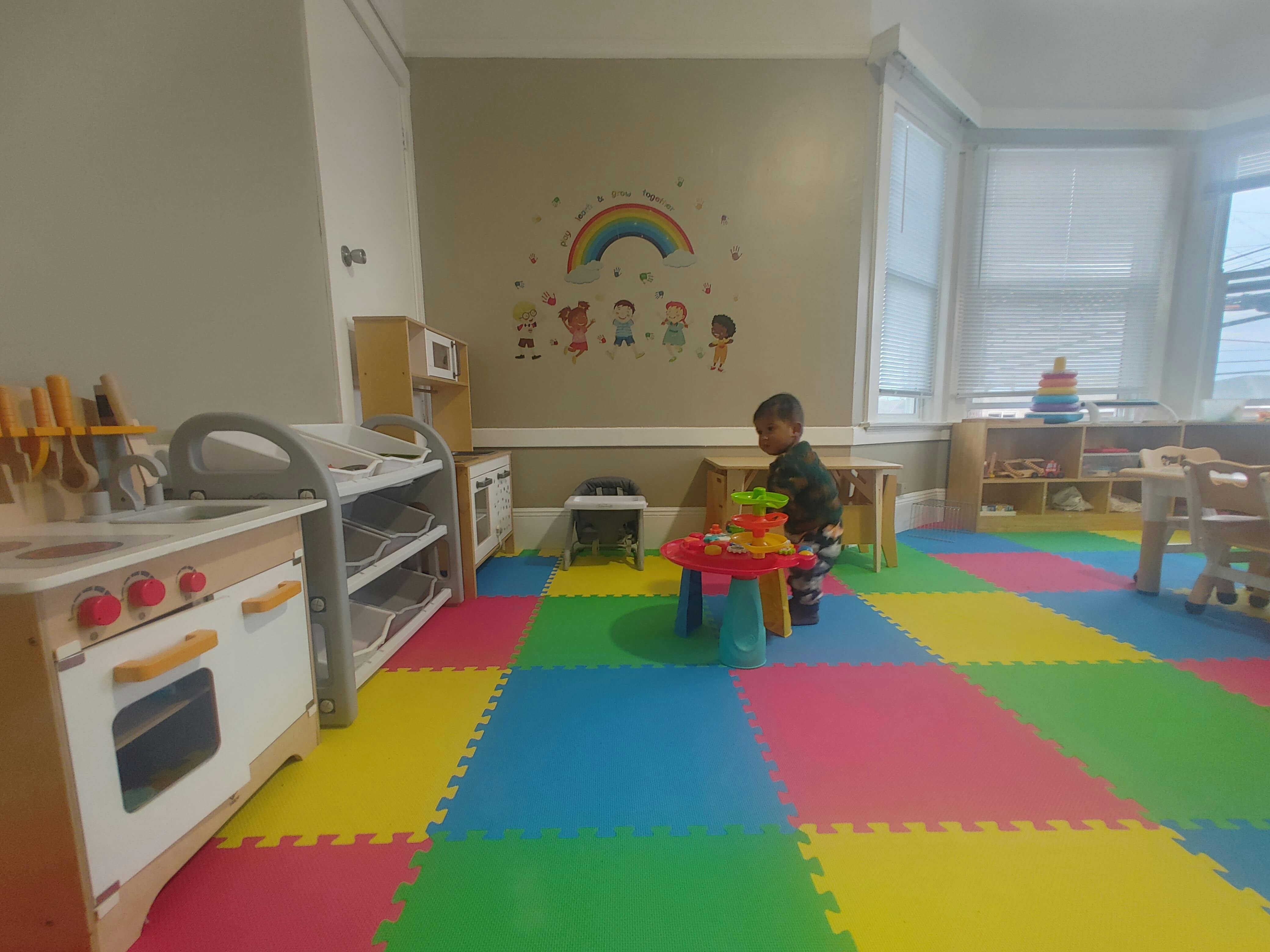 Child playing at a small table in a room with colorful floor mats
