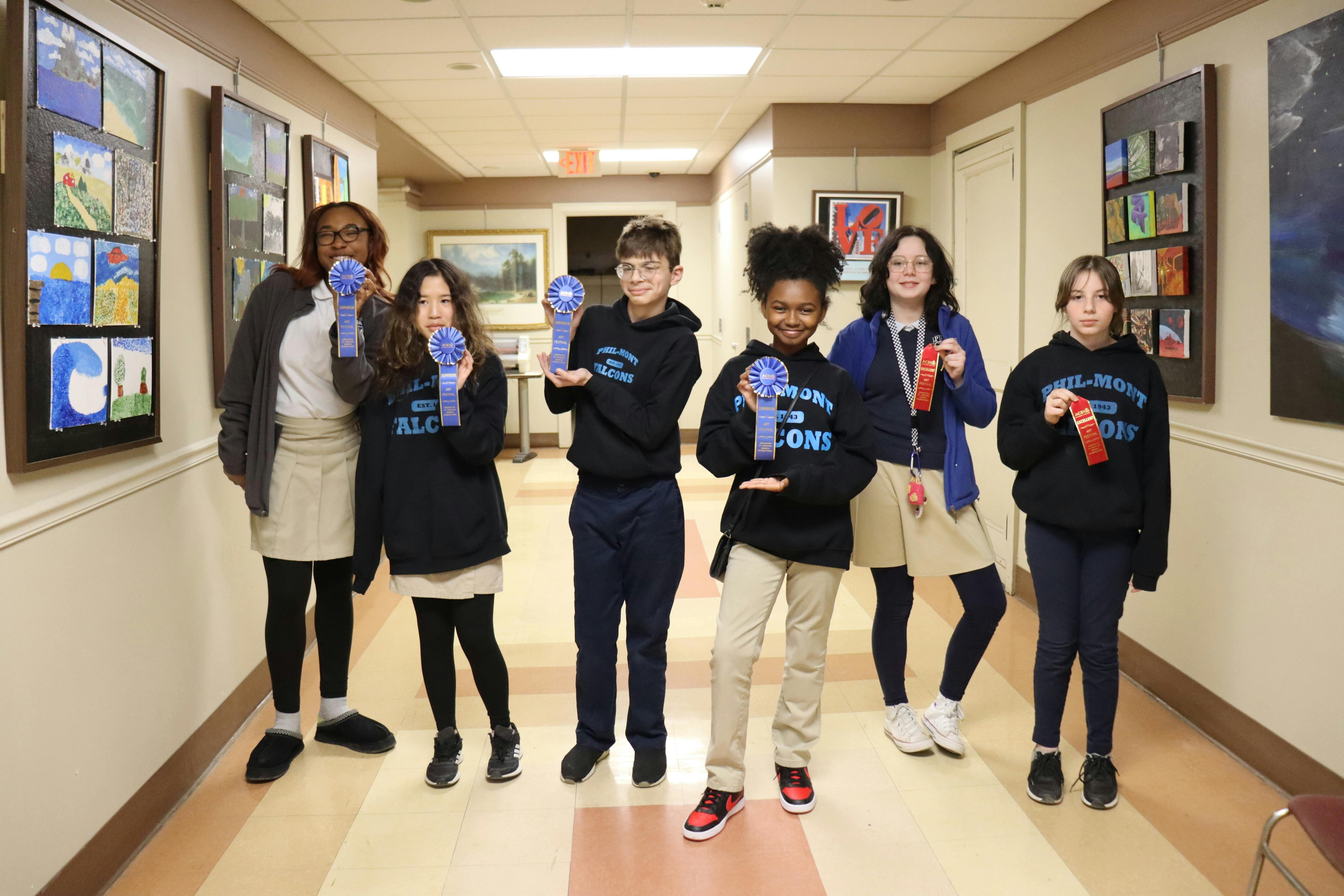 Group of teens and children holding ribbons in a hallway