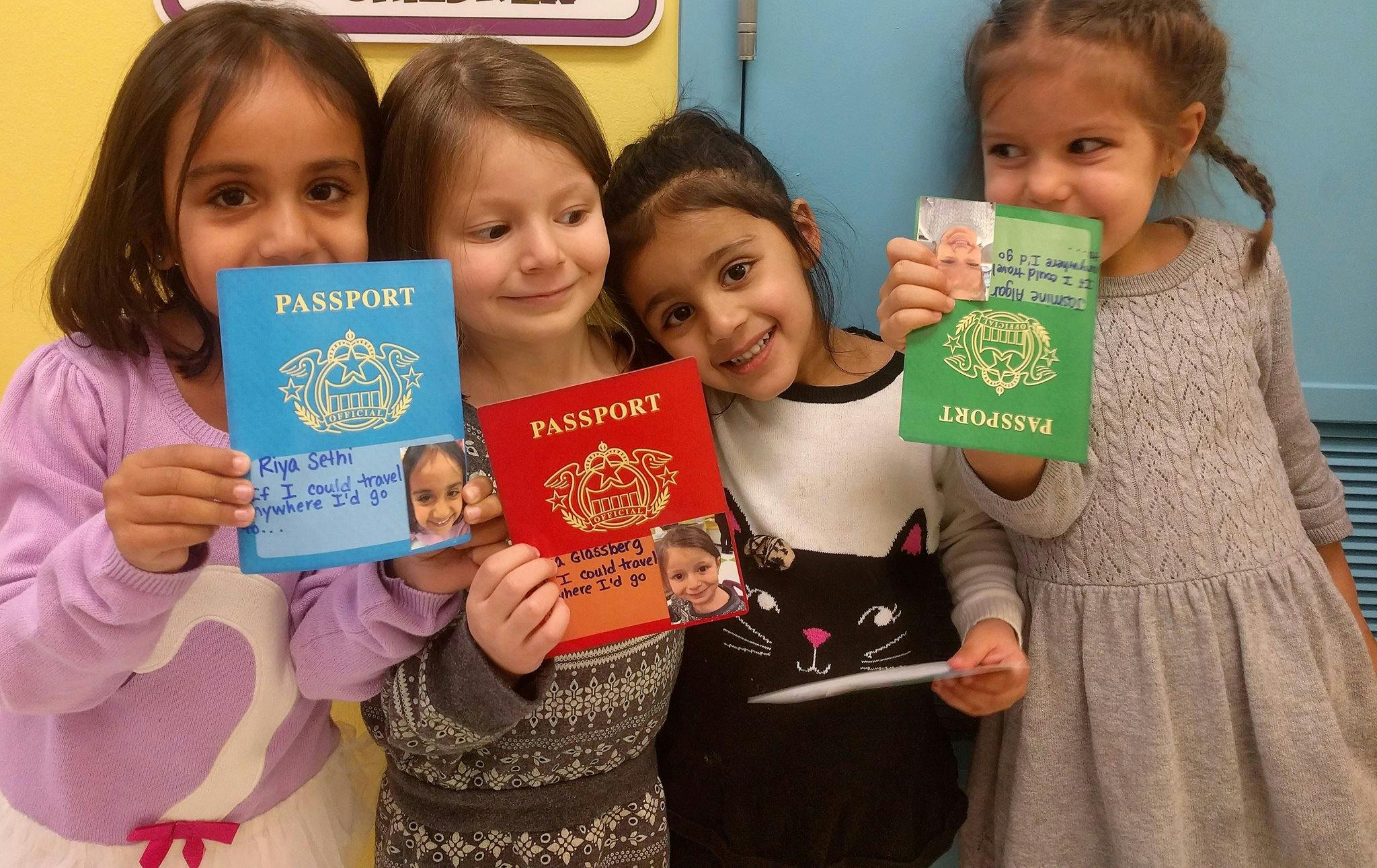 Four children holding up colorful play passports
