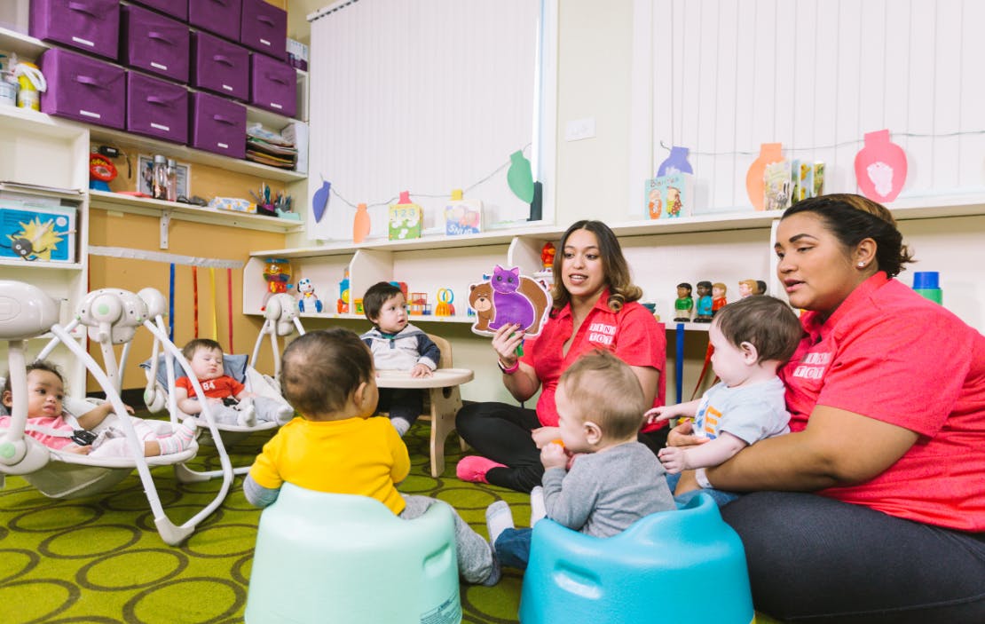 Two people with multiple children in a classroom