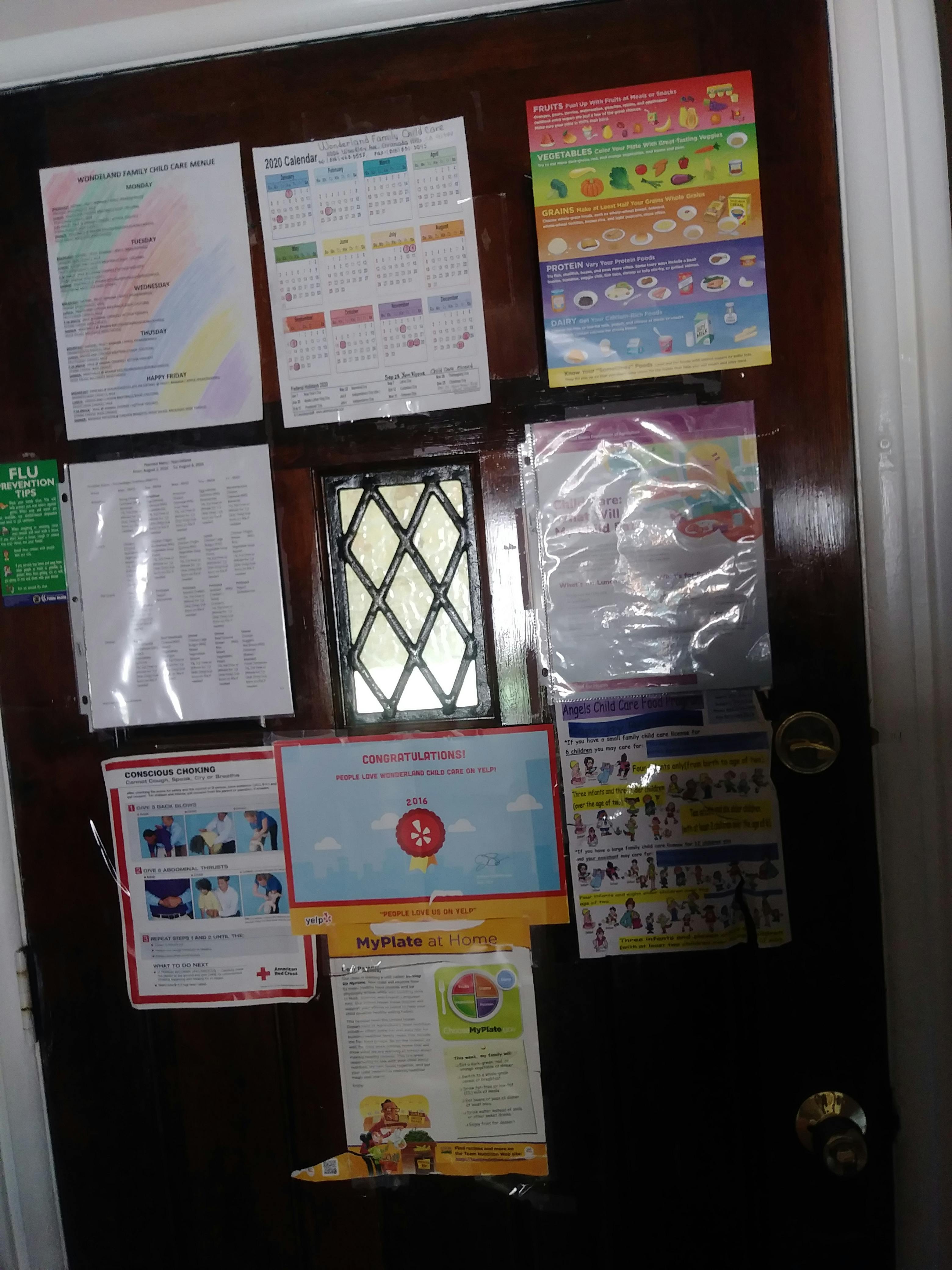 Door covered with various informational posters and a small window
