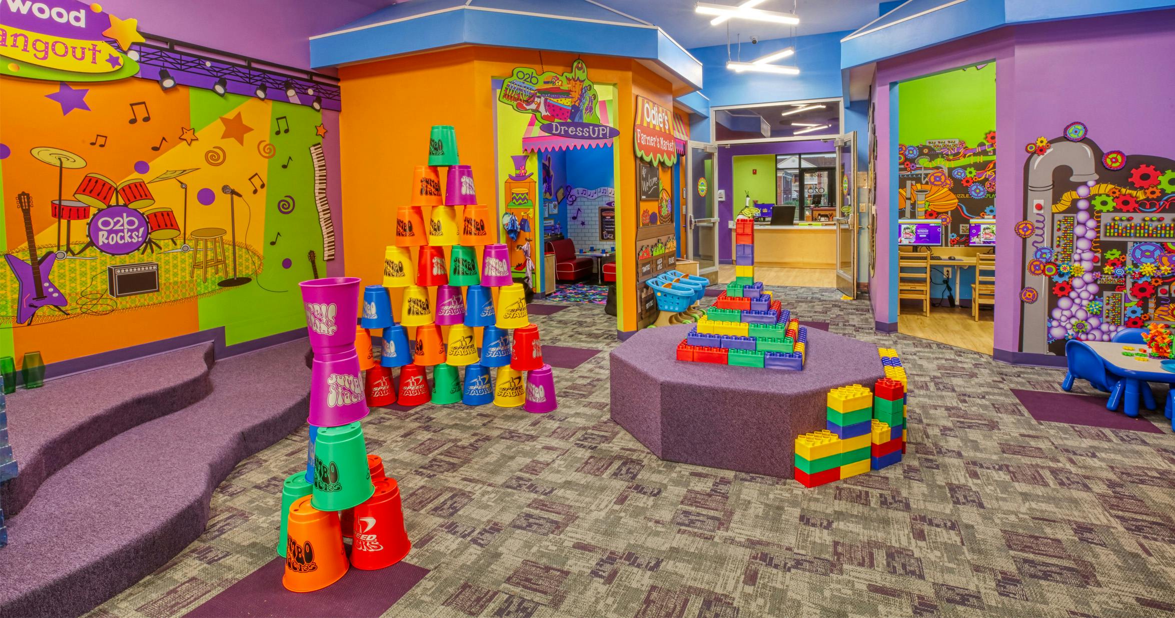 Children's play area with colorful walls, large building blocks, and cup towers
