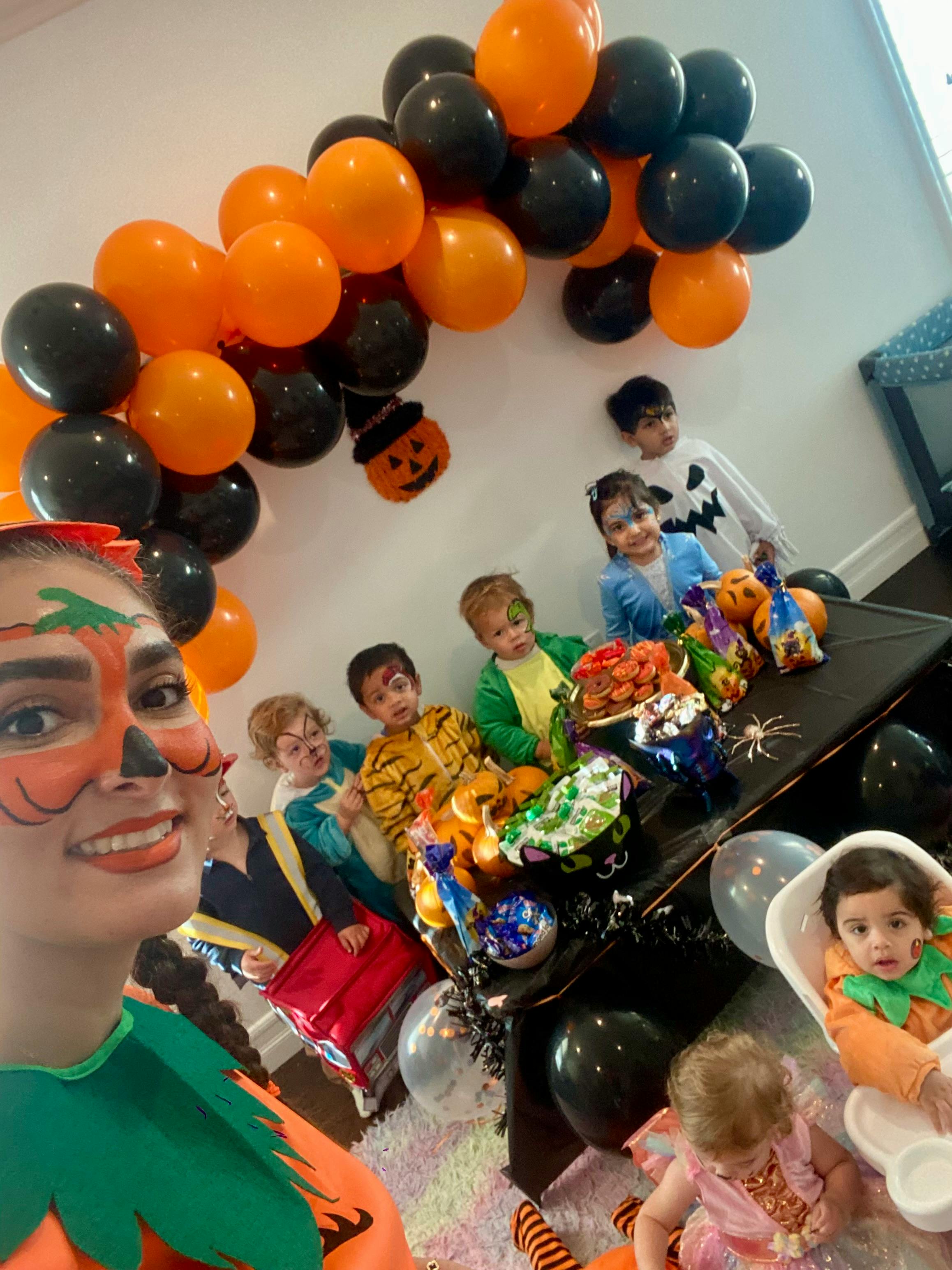 People in Halloween costumes with balloons and treats