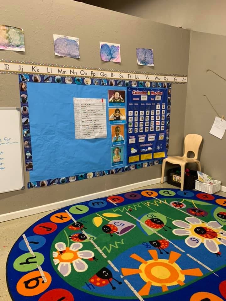 Classroom with a bulletin board, calendar, and colorful rug