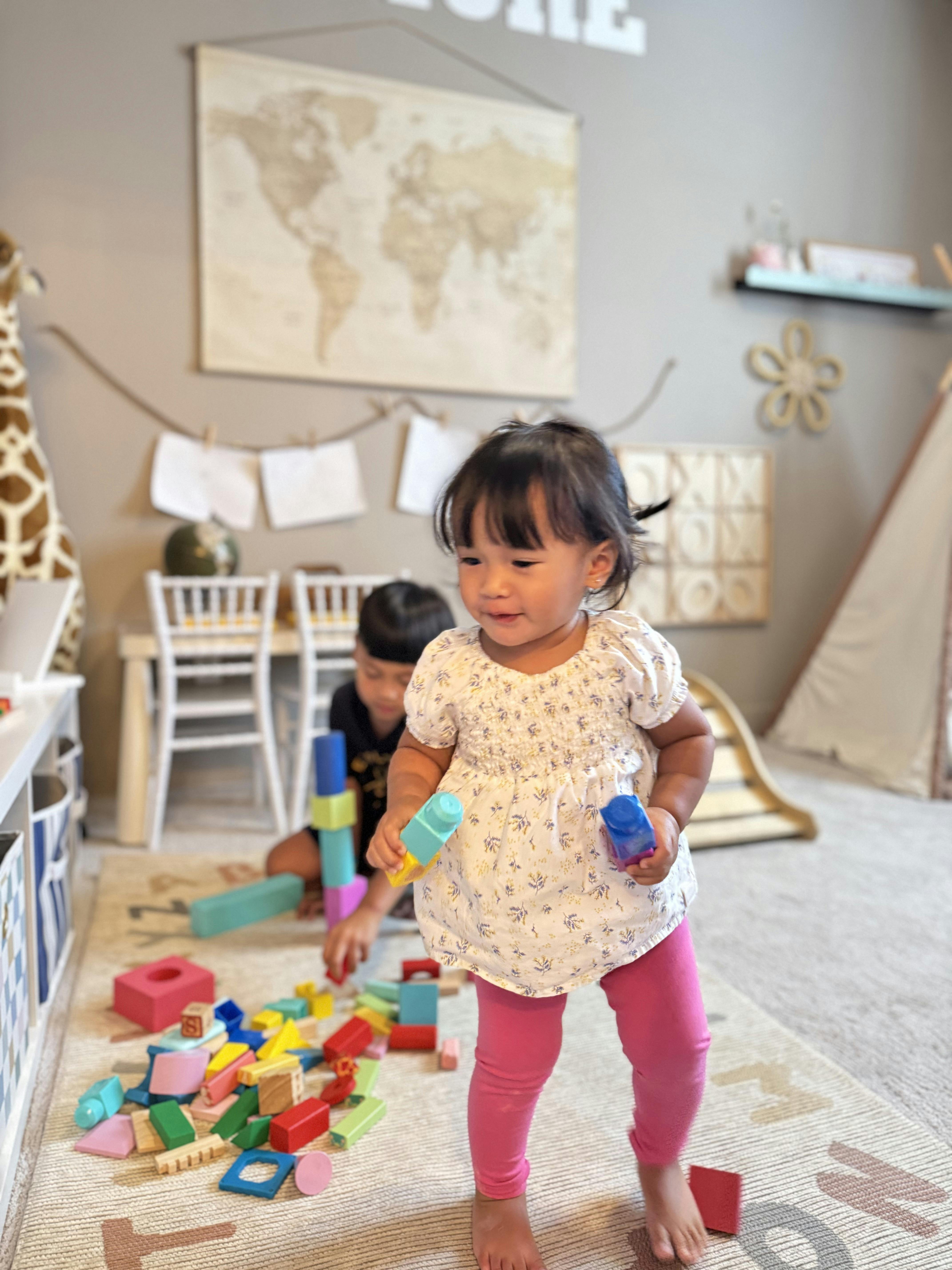 Child playing with colorful toy building blocks in a room