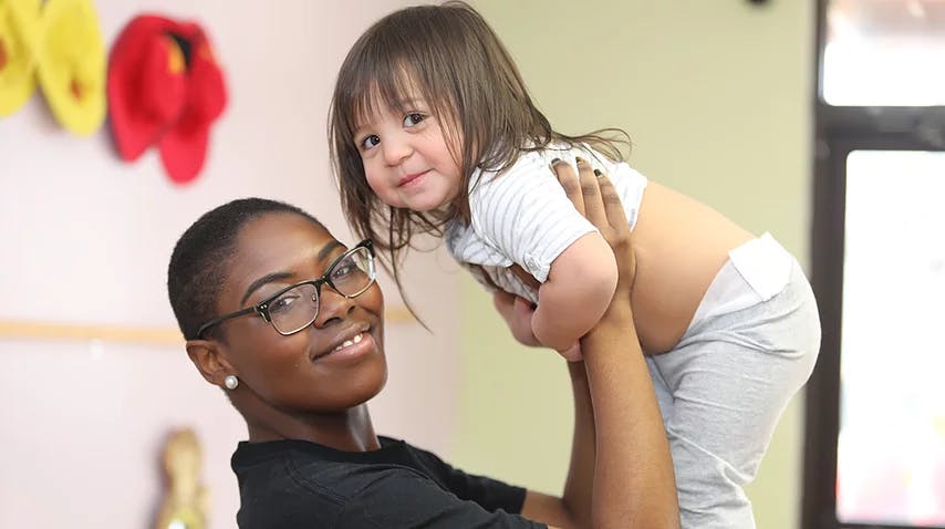 Person holding a child up in the air