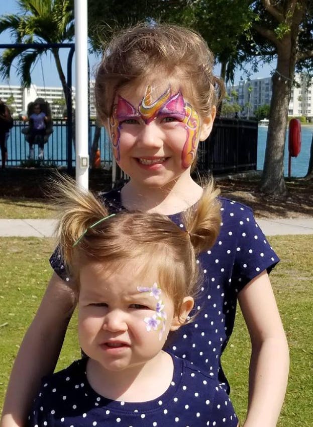 Two children with face paint, one in front of the other
