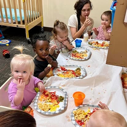 Adult and multiple children eating at a table