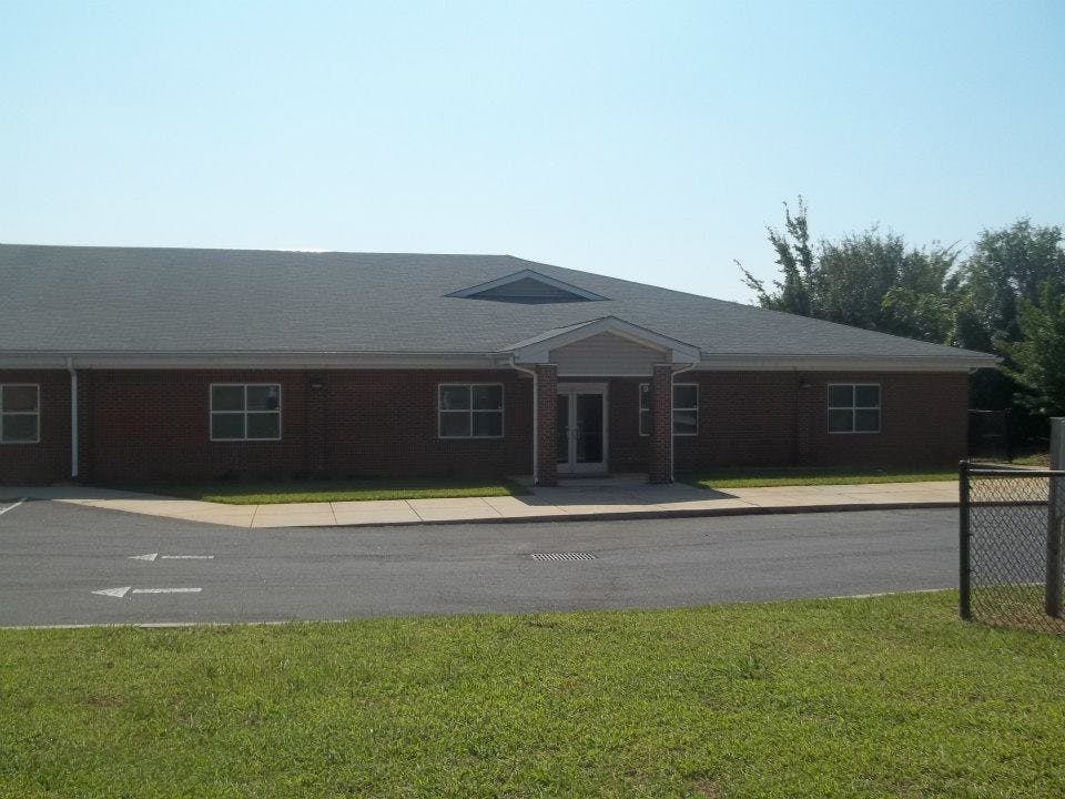 Brick building with a dark roof and a small covered entrance