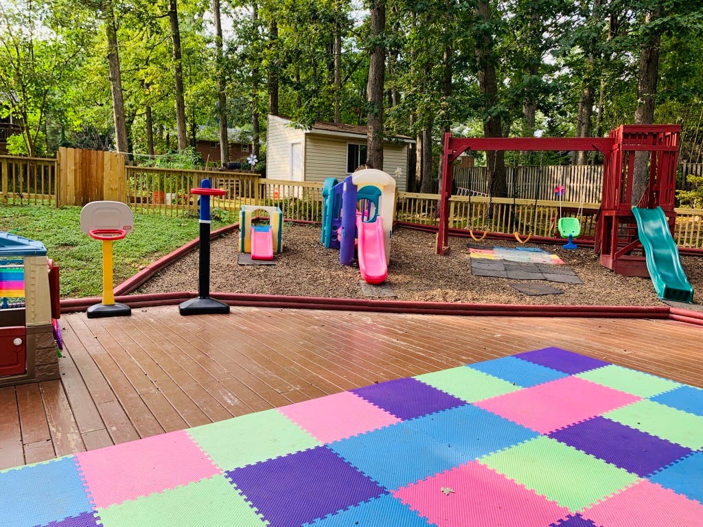 Outdoor playground with slides, swings, and colorful floor mats