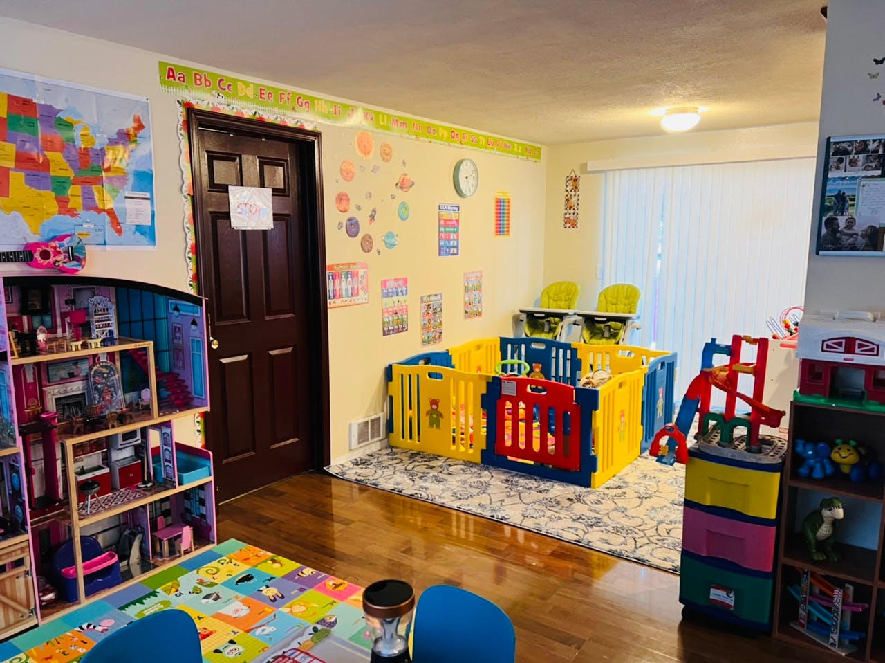 Playroom with colorful playpen, dollhouse, and map on the wall