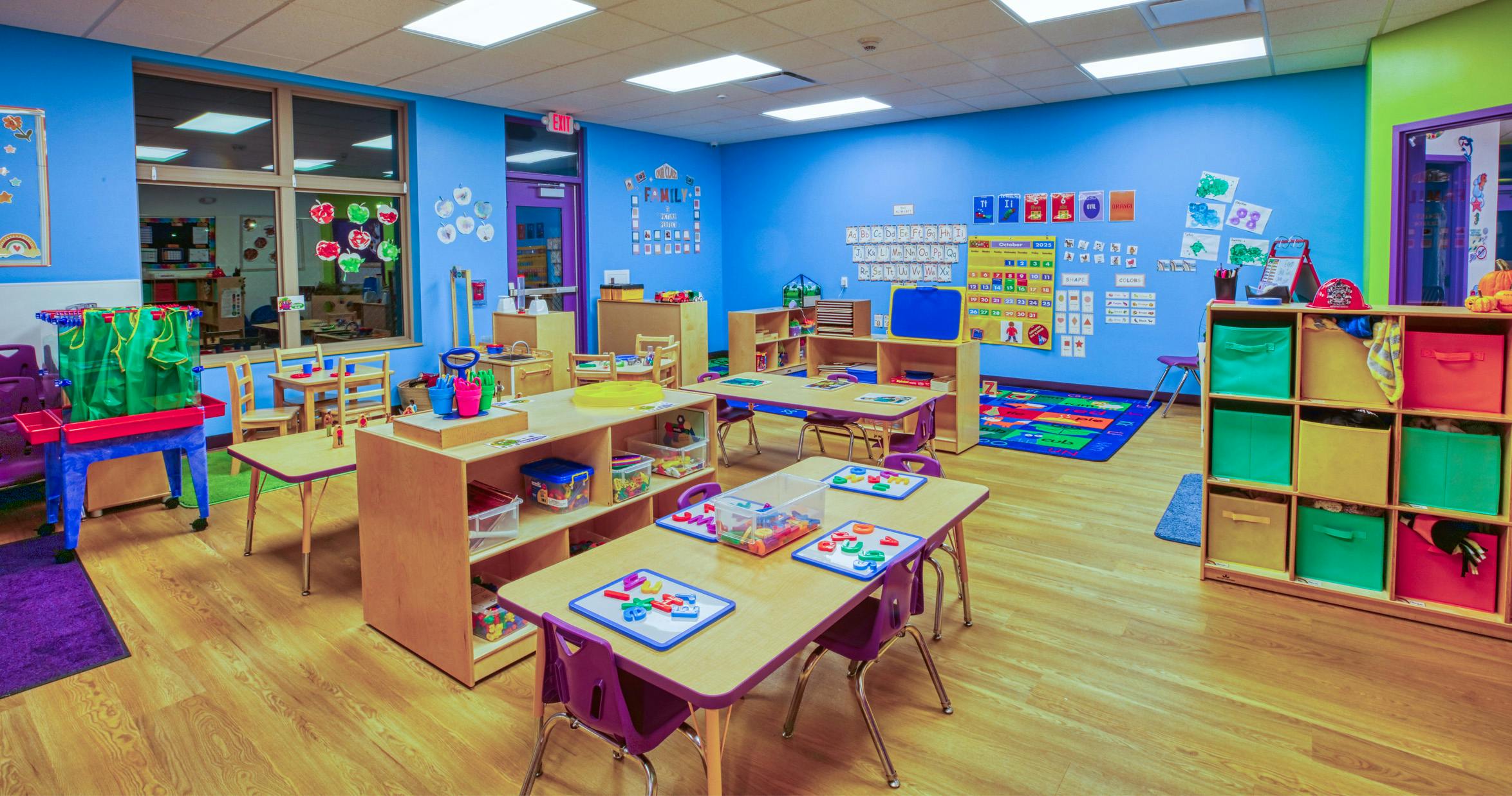 Classroom with tables, chairs, and colorful learning aids on walls