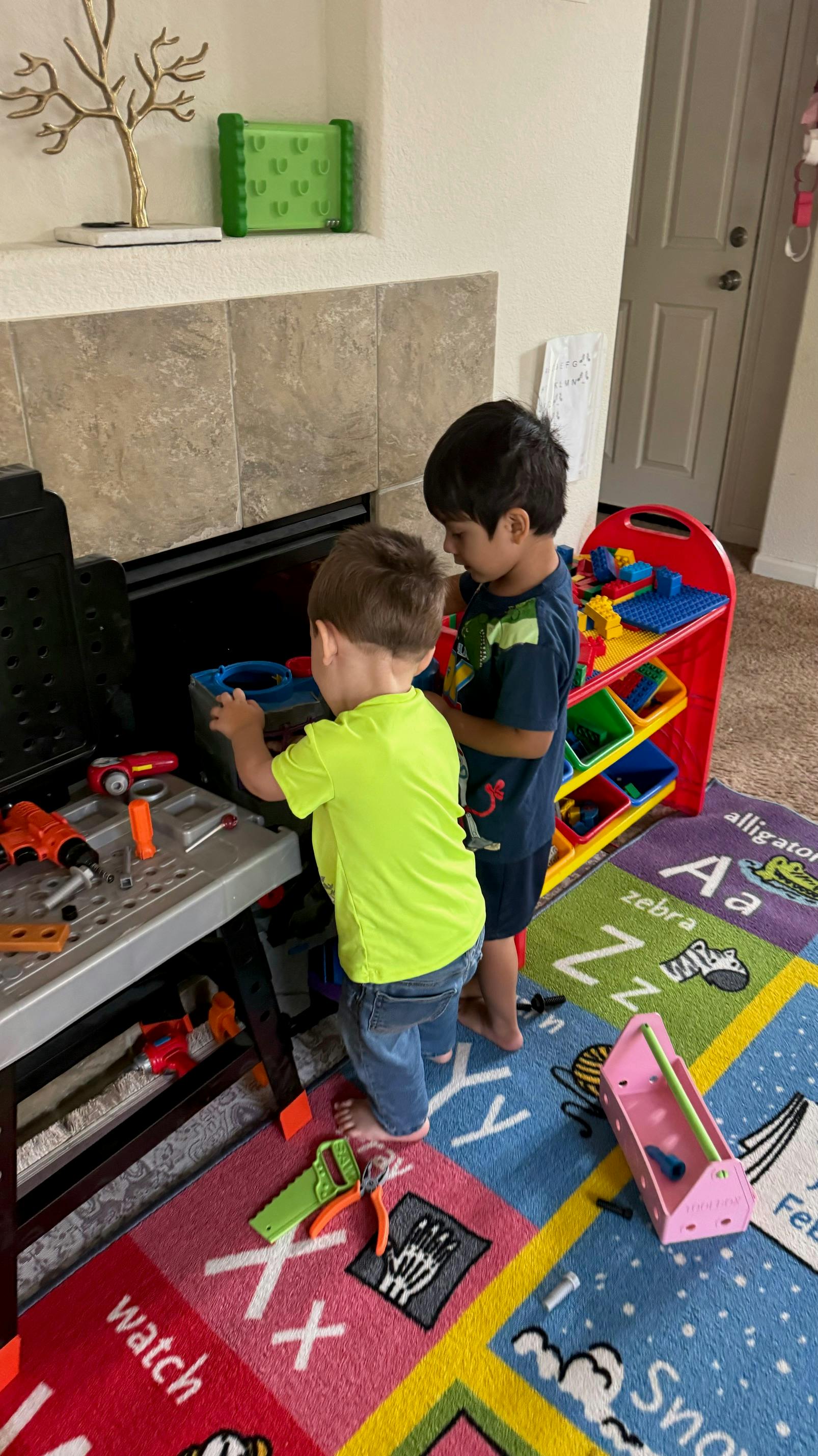 Two children playing with toy tools at a workbench