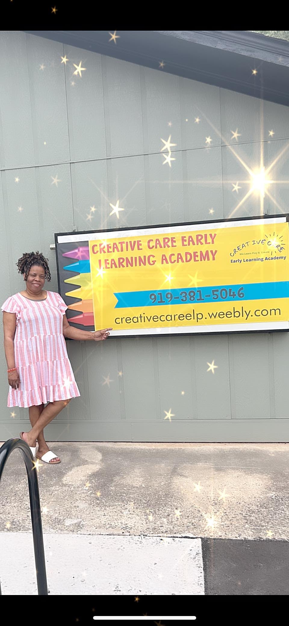 Person standing next to a sign for Creative Care Early Learning Academy