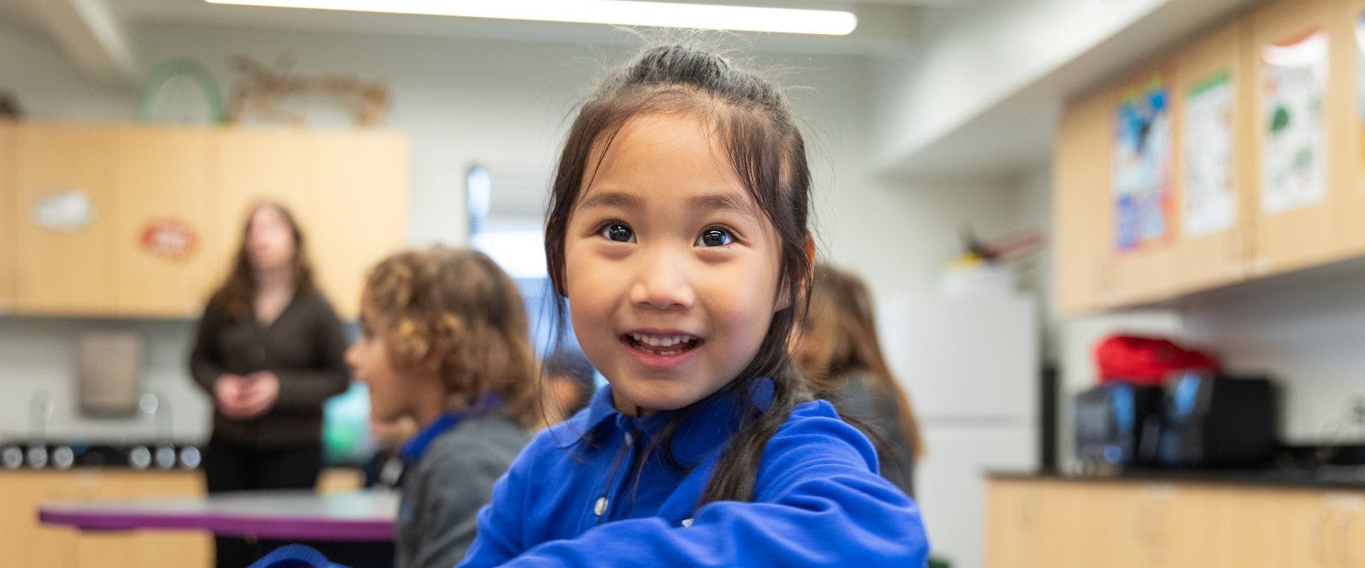 Child smiling in a classroom