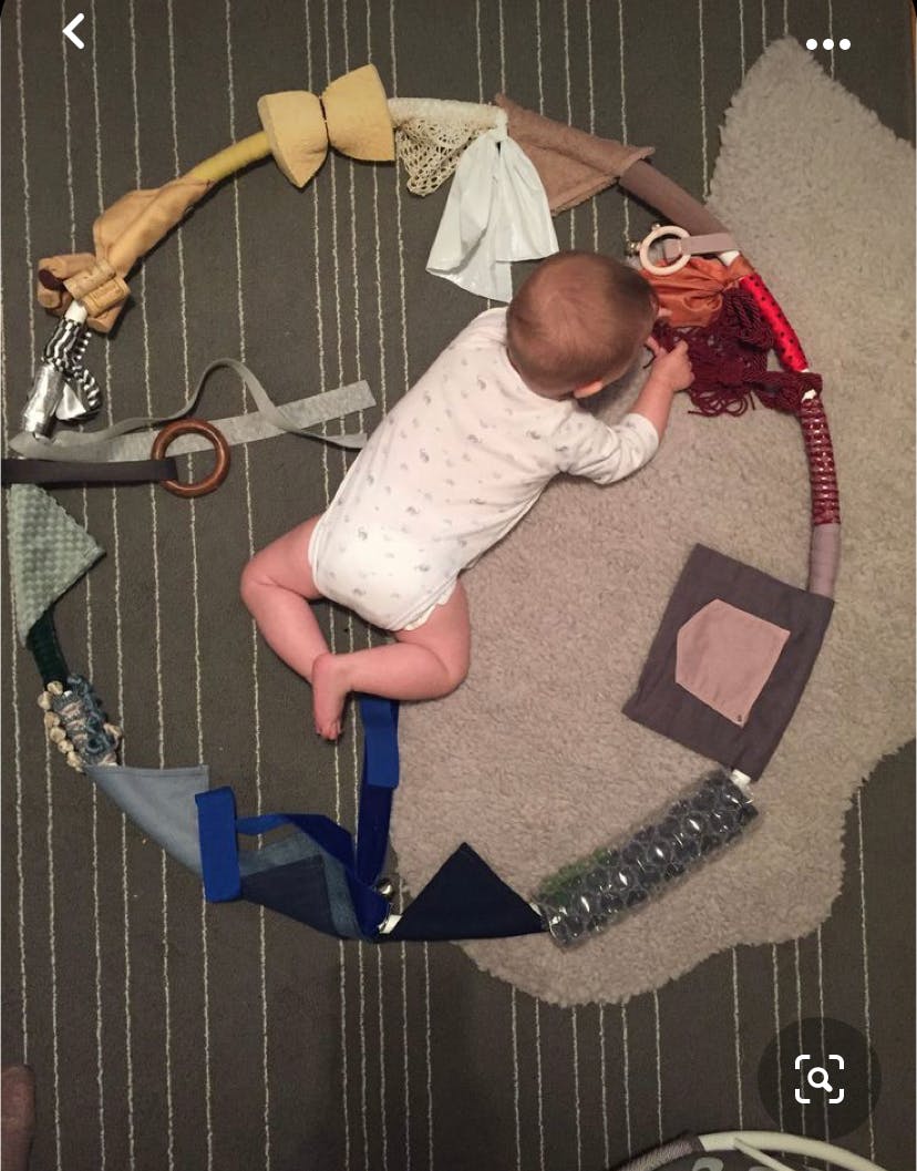Child on floor playing with a sensory activity ring