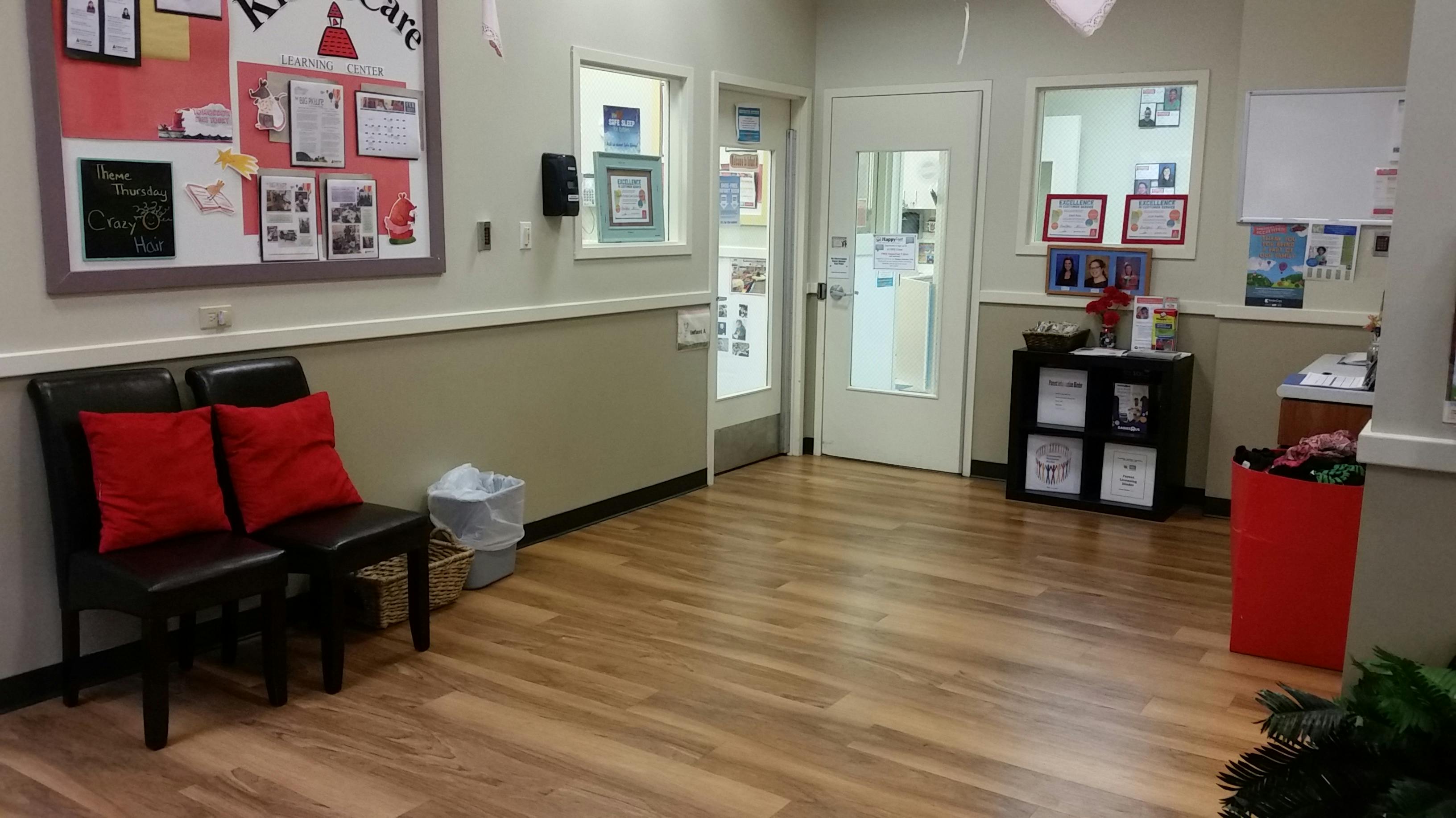 waiting area in a childcare center with bulletin board, chairs, and doors