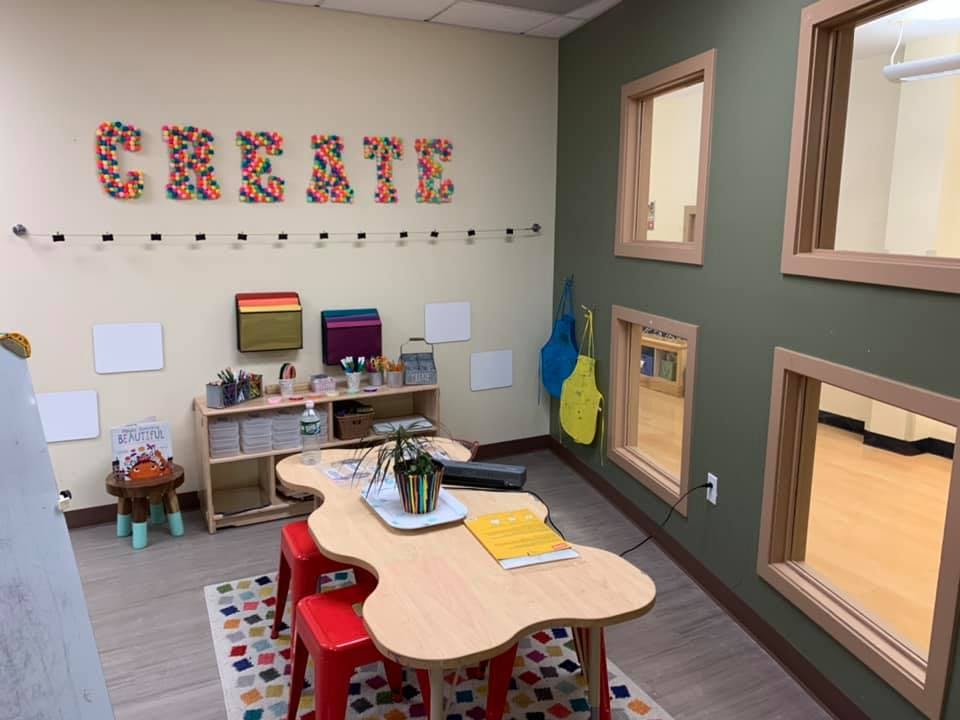 Classroom with a table, chairs, and the word CREATE on the wall