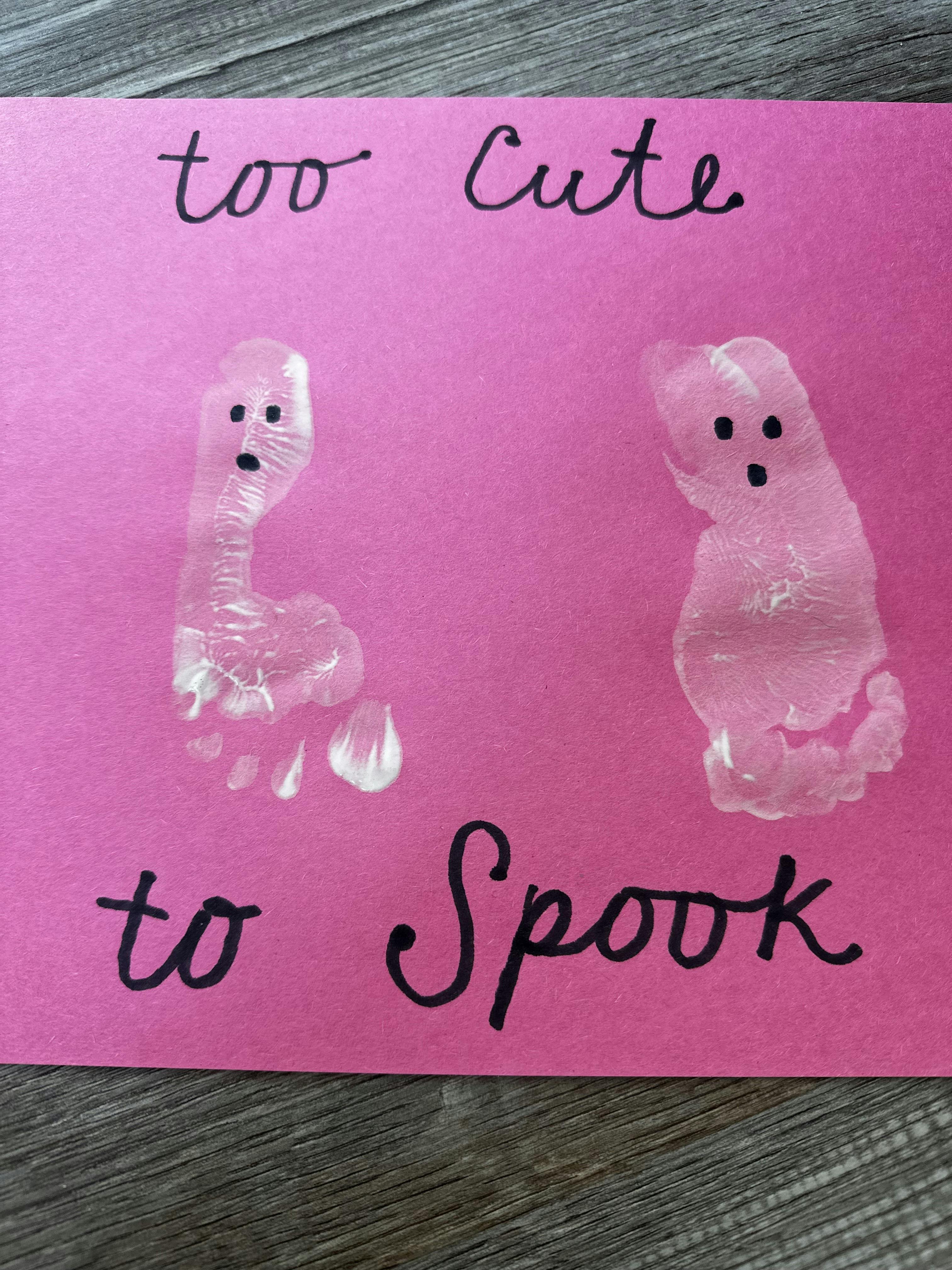 White footprint ghosts on pink paper with the text too cute to spook