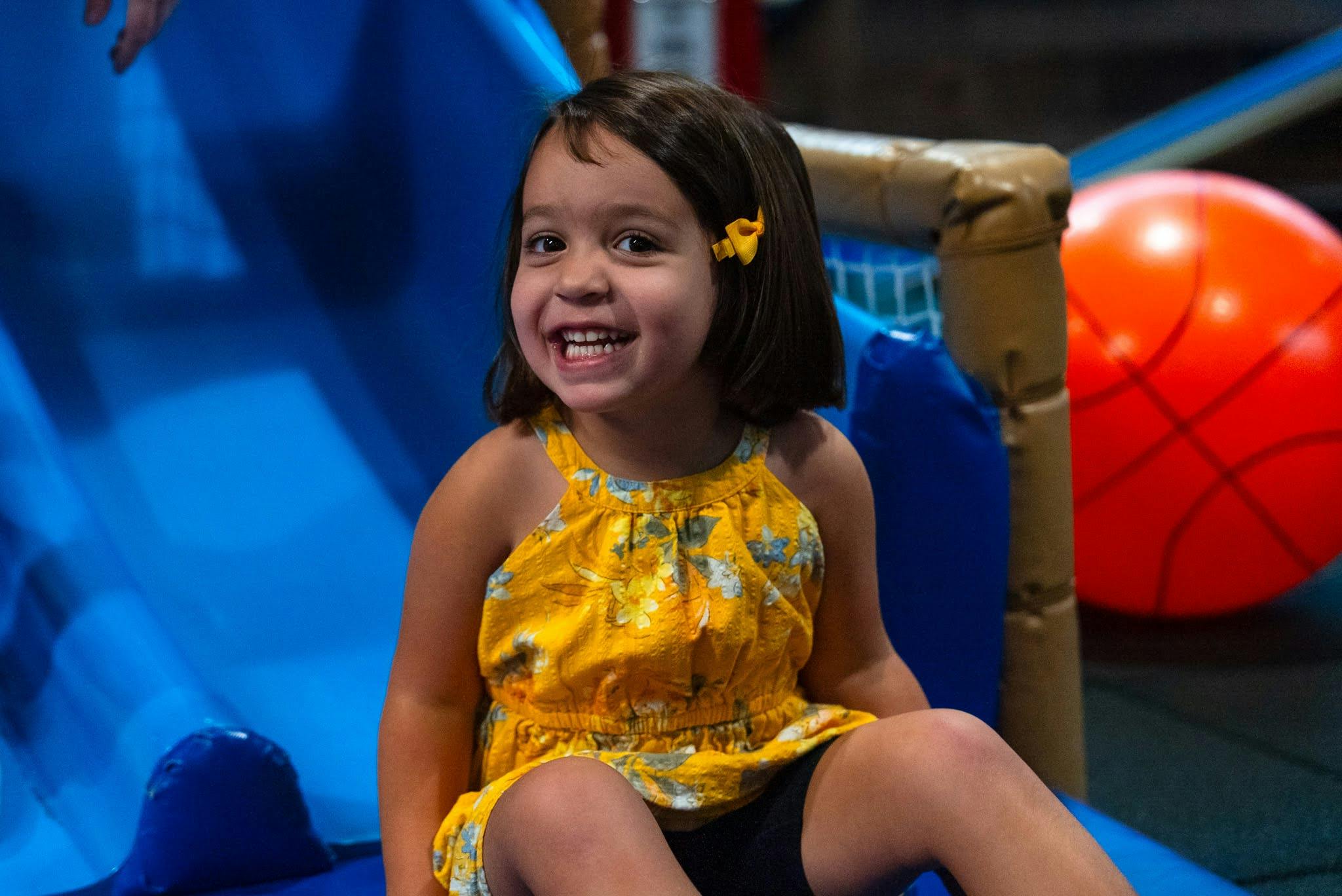 Child smiling on a blue play structure