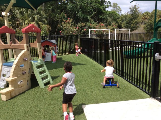 Children playing on a playground with artificial turf