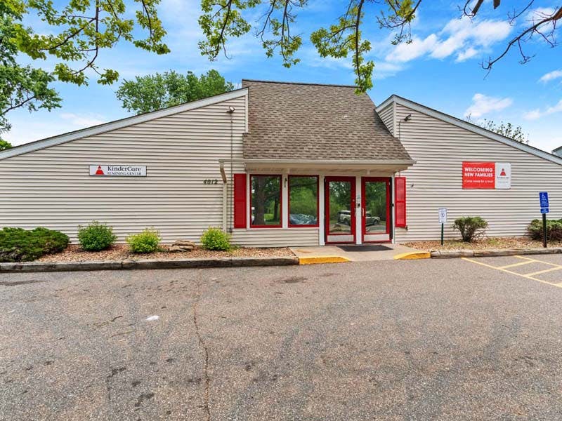 KinderCare Learning Center building with red doors and red shutters