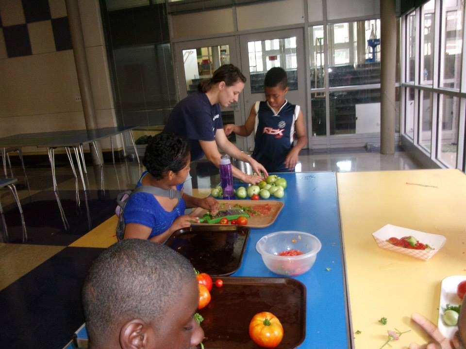Adult and children preparing food at a table