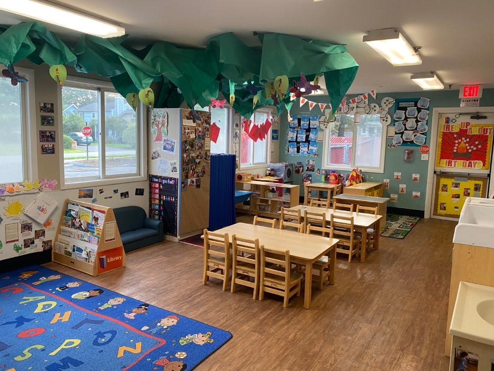 Empty colorful preschool classroom with small tables and chairs