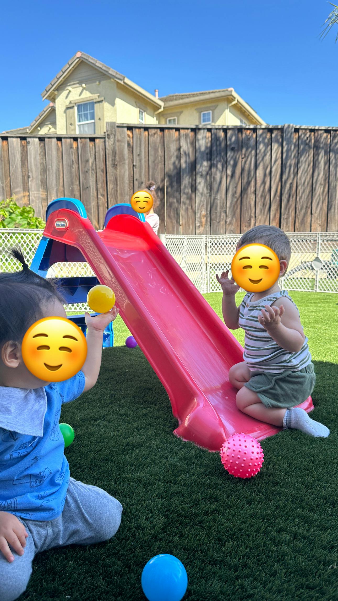 Children playing with a slide and balls on grass