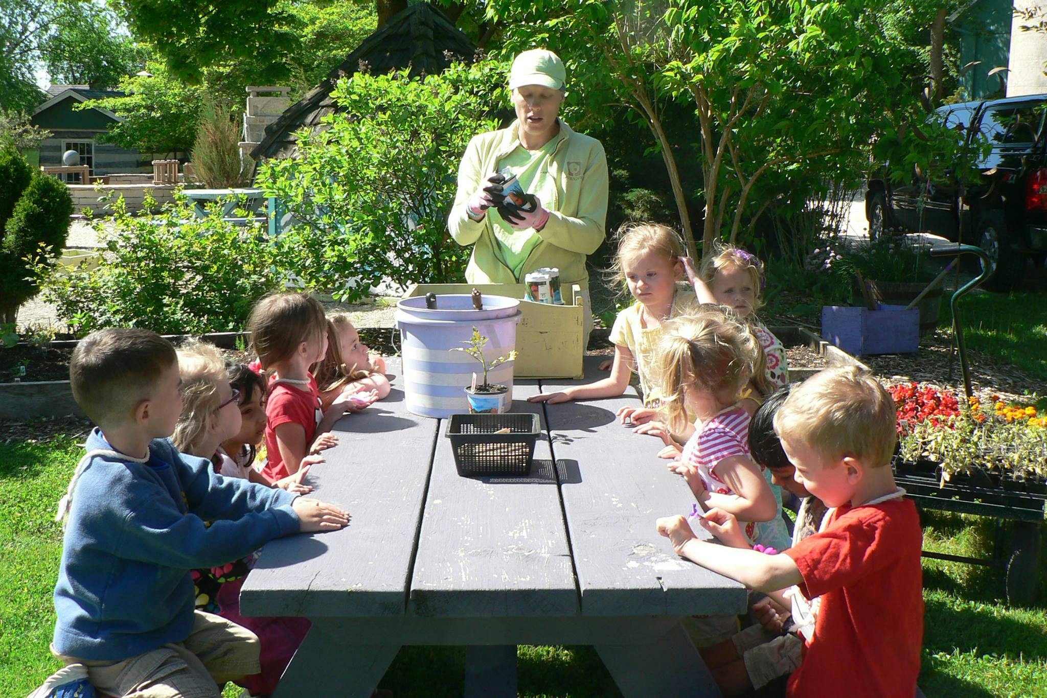 Adult and children at a picnic table outdoors