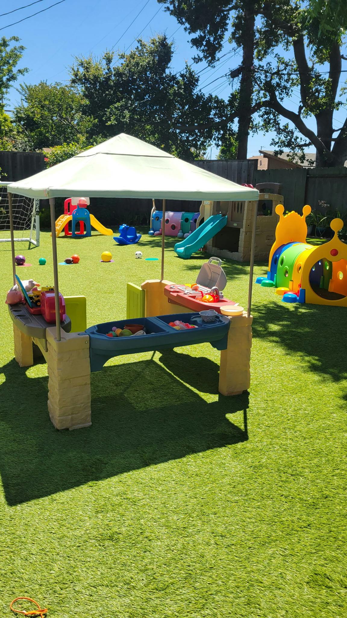 Outdoor children playground with a play kitchen set on artificial grass