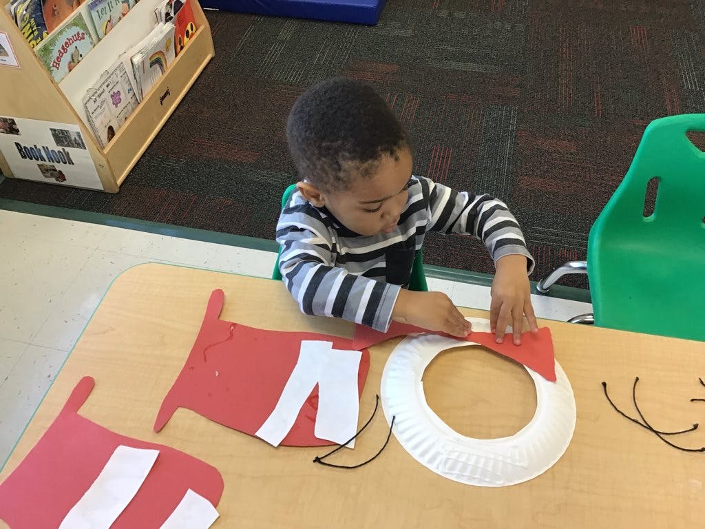 Child making a craft at a table