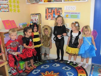 Children in costumes standing in a classroom