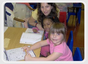 Adult and two children looking at camera