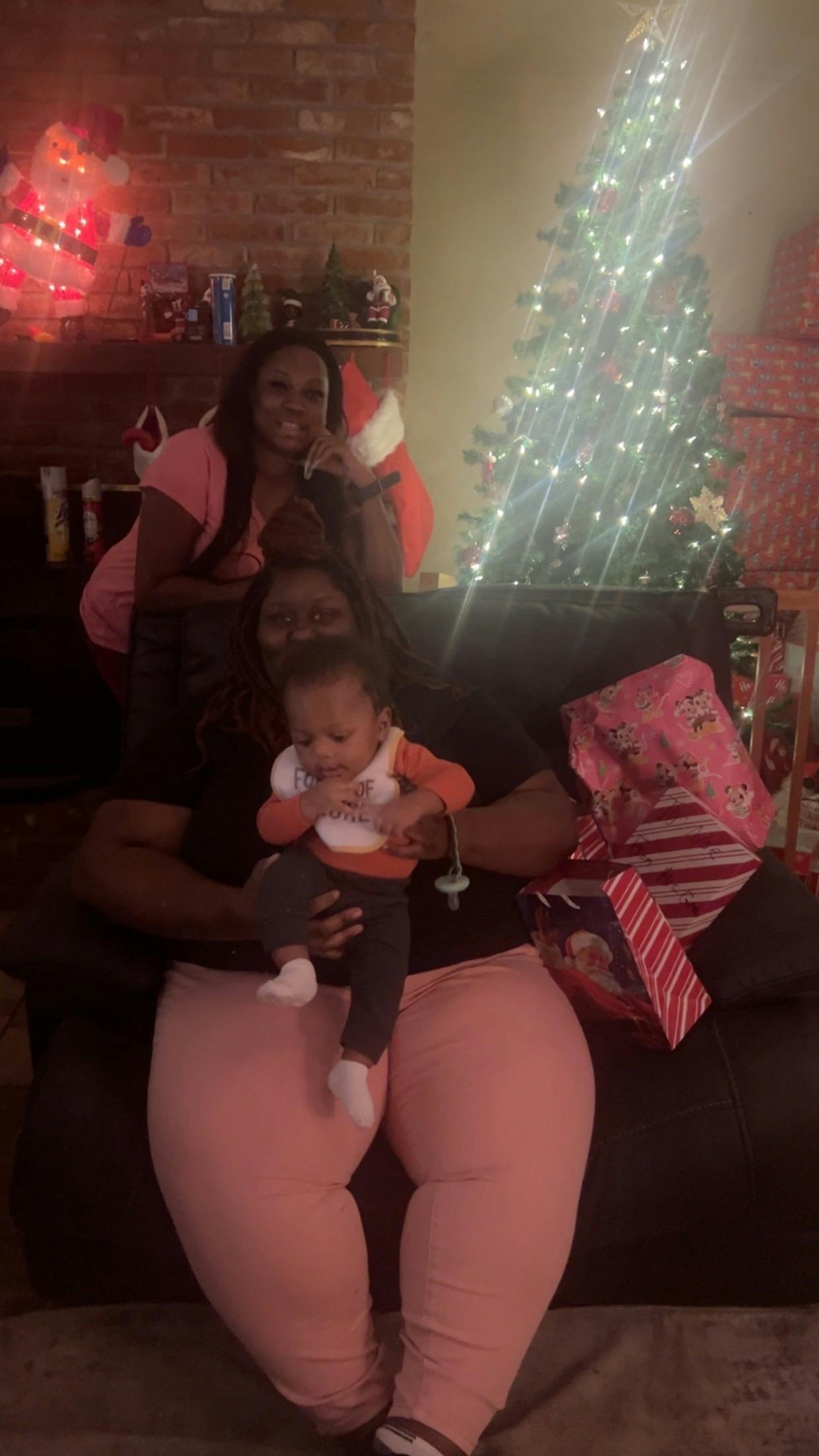 Person holding a child, another person in the background