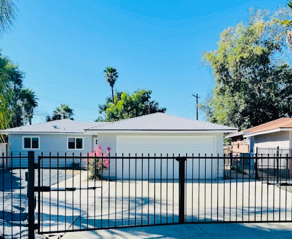House with a garage and a black metal fence in front