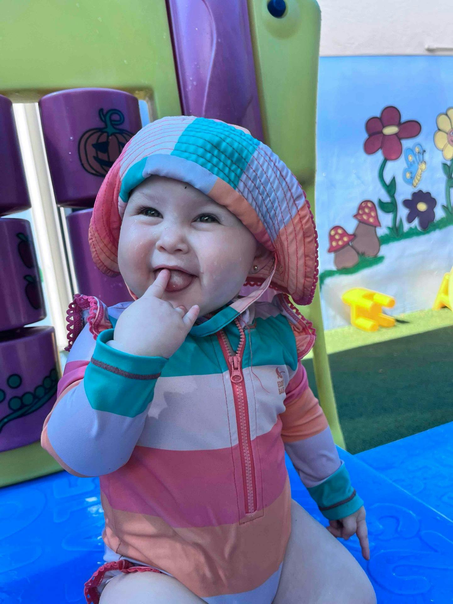 Child in a sun hat with finger in mouth