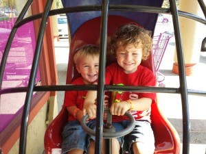 Two children sitting in a play structure