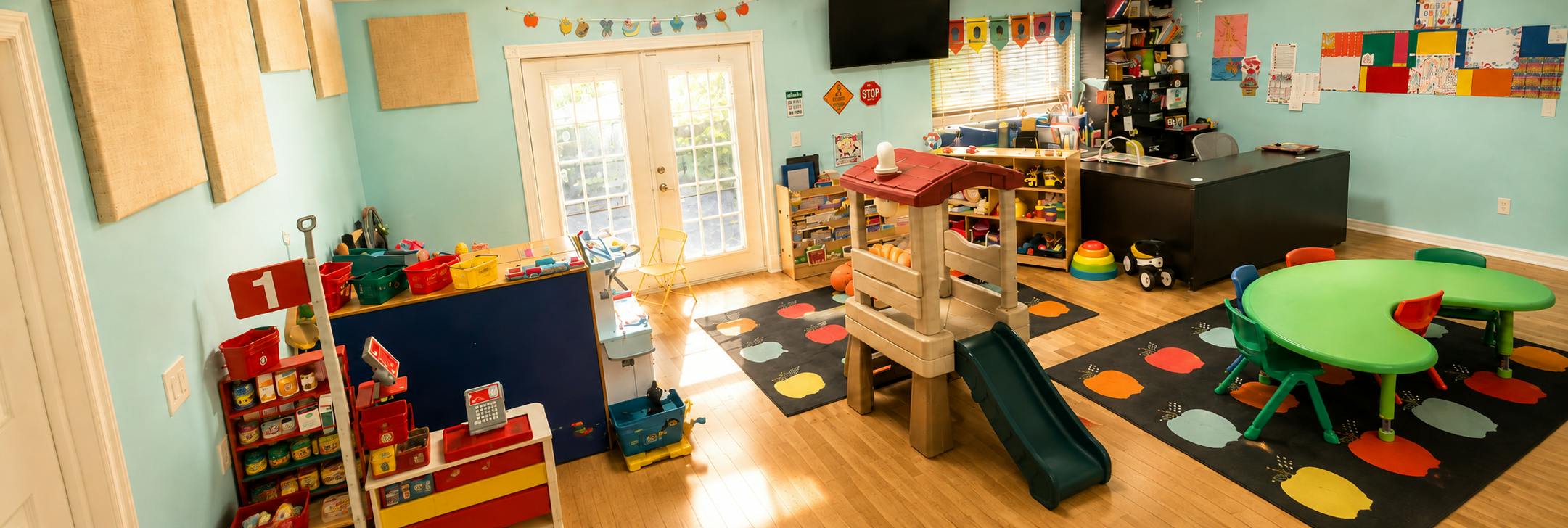 Colorful playroom with a small play slide and activity tables