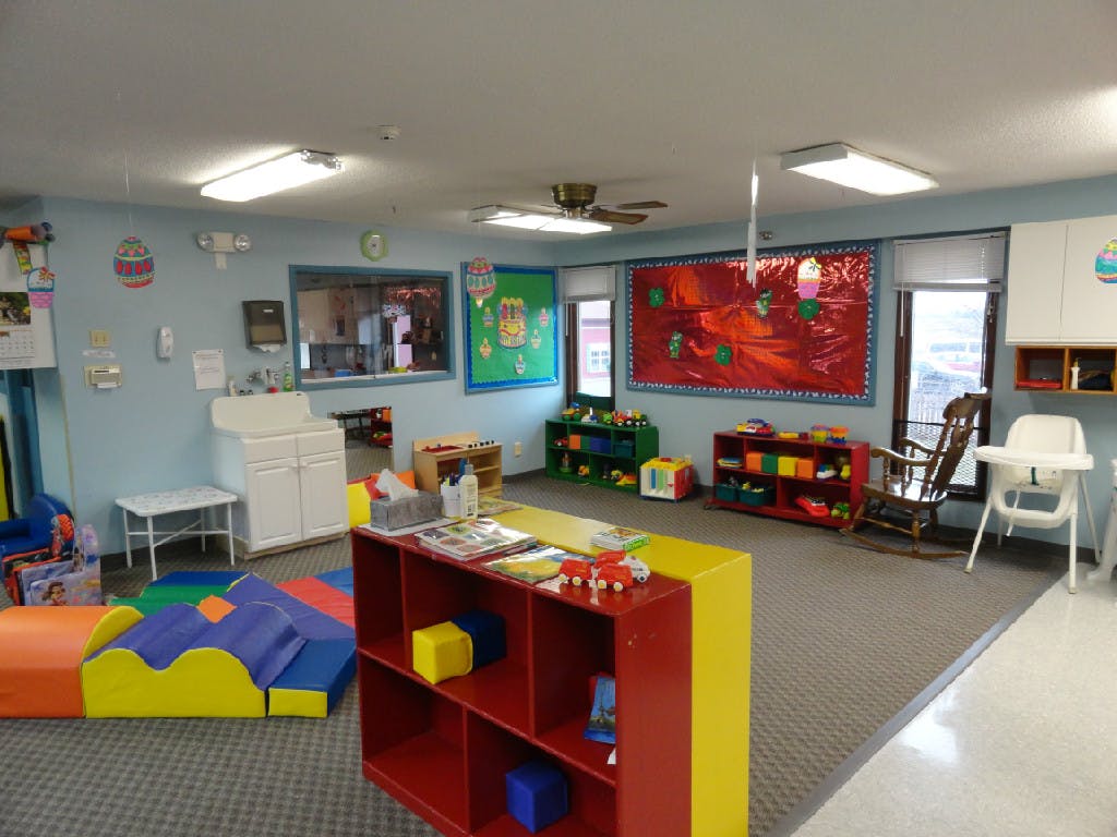 Playroom with colorful soft play equipment and shelves of shelves with toys