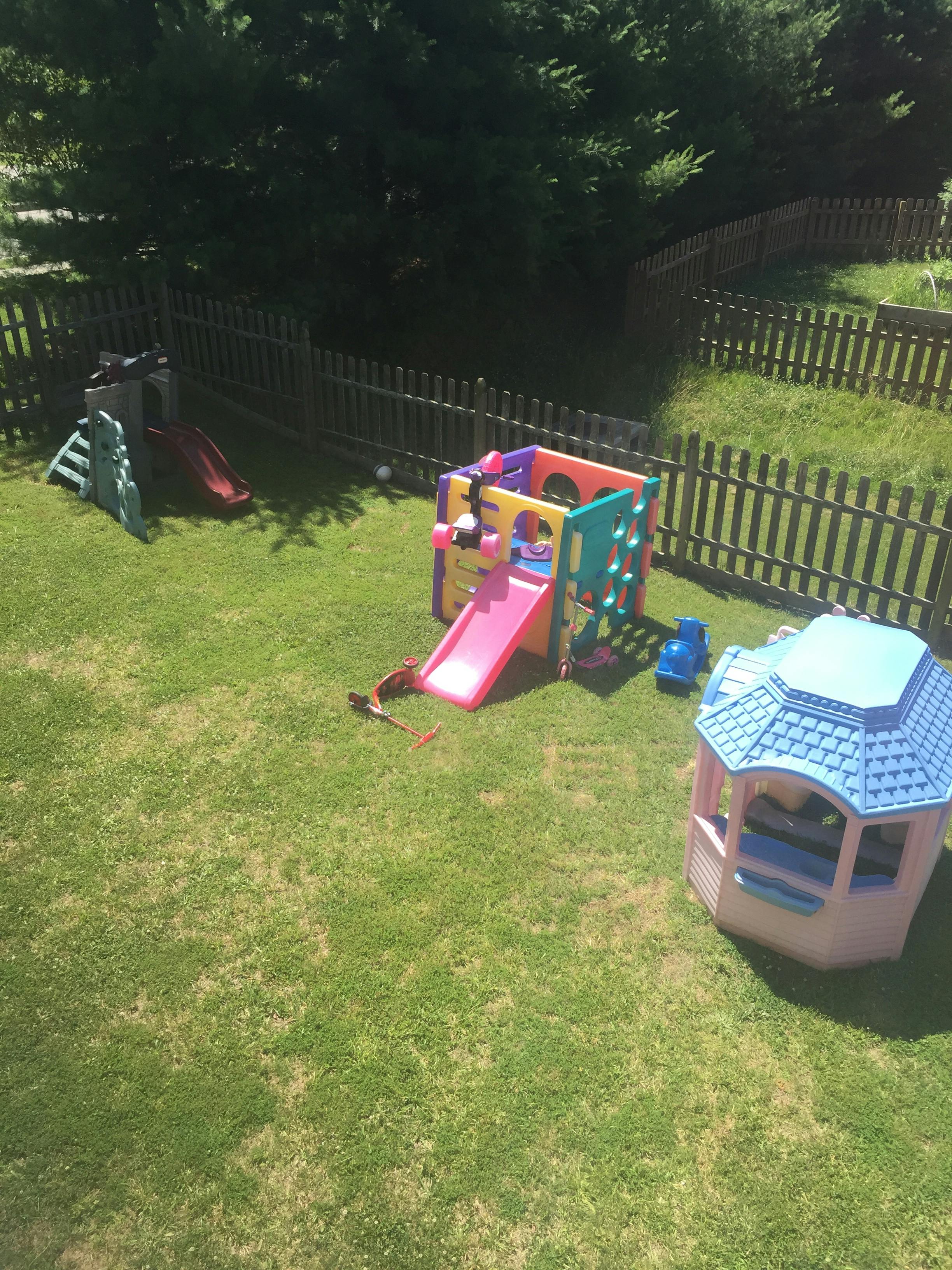 Playground with colorful slides and playhouses on green grass