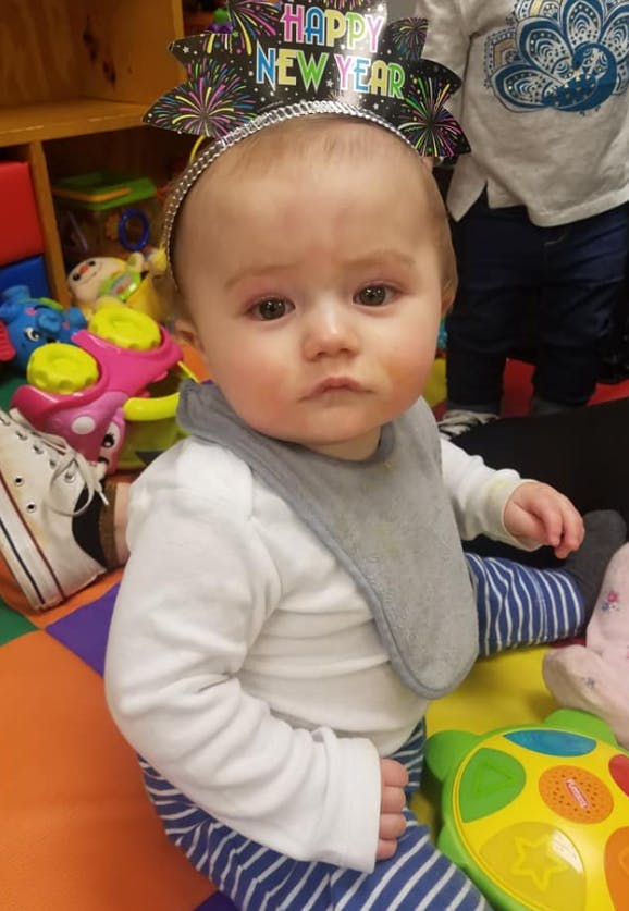 Child wearing a Happy New Year headband and a bib