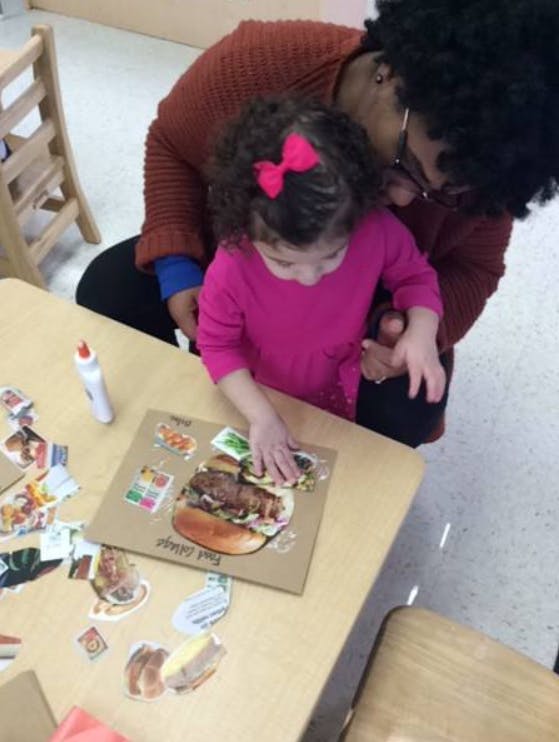 Person and child making a collage at a table