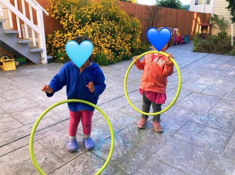 Two children playing with hula hoops outdoors