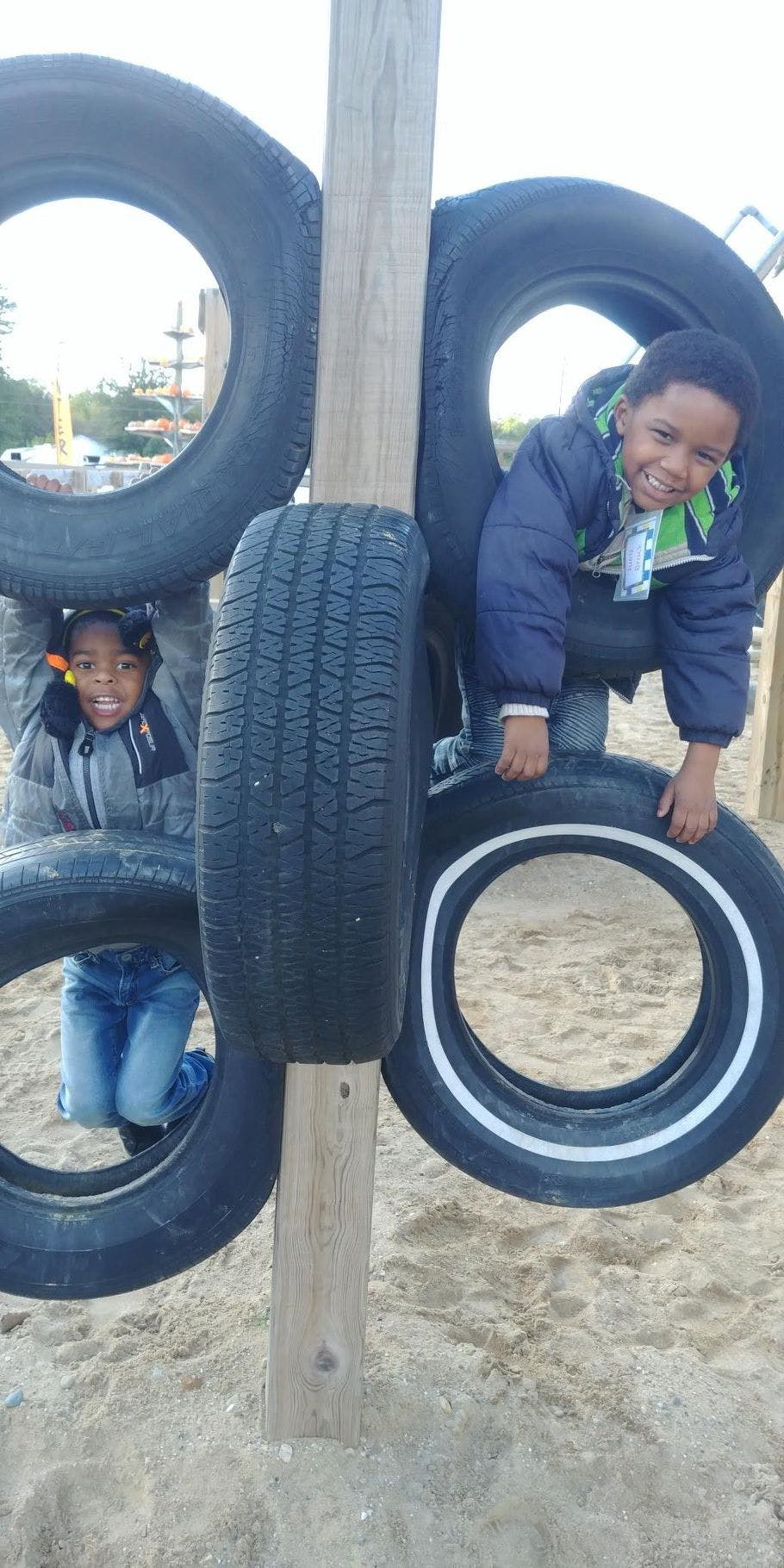 Two children playing on a tire structure