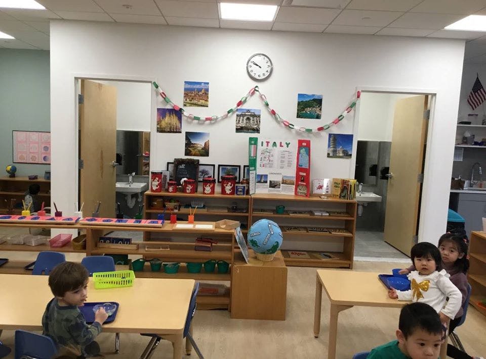 Children in a classroom with tables and shelves