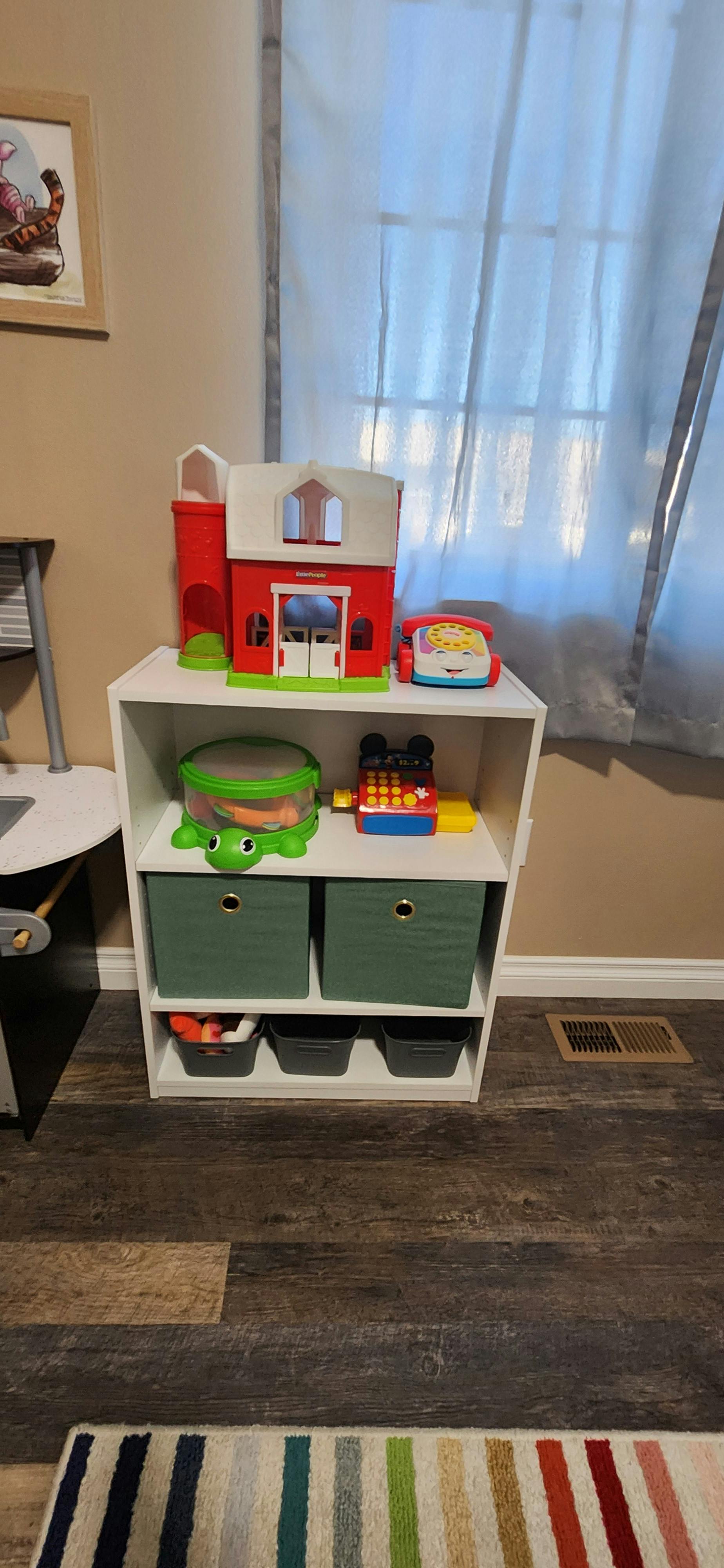 White shelving unit with toys and storage bins